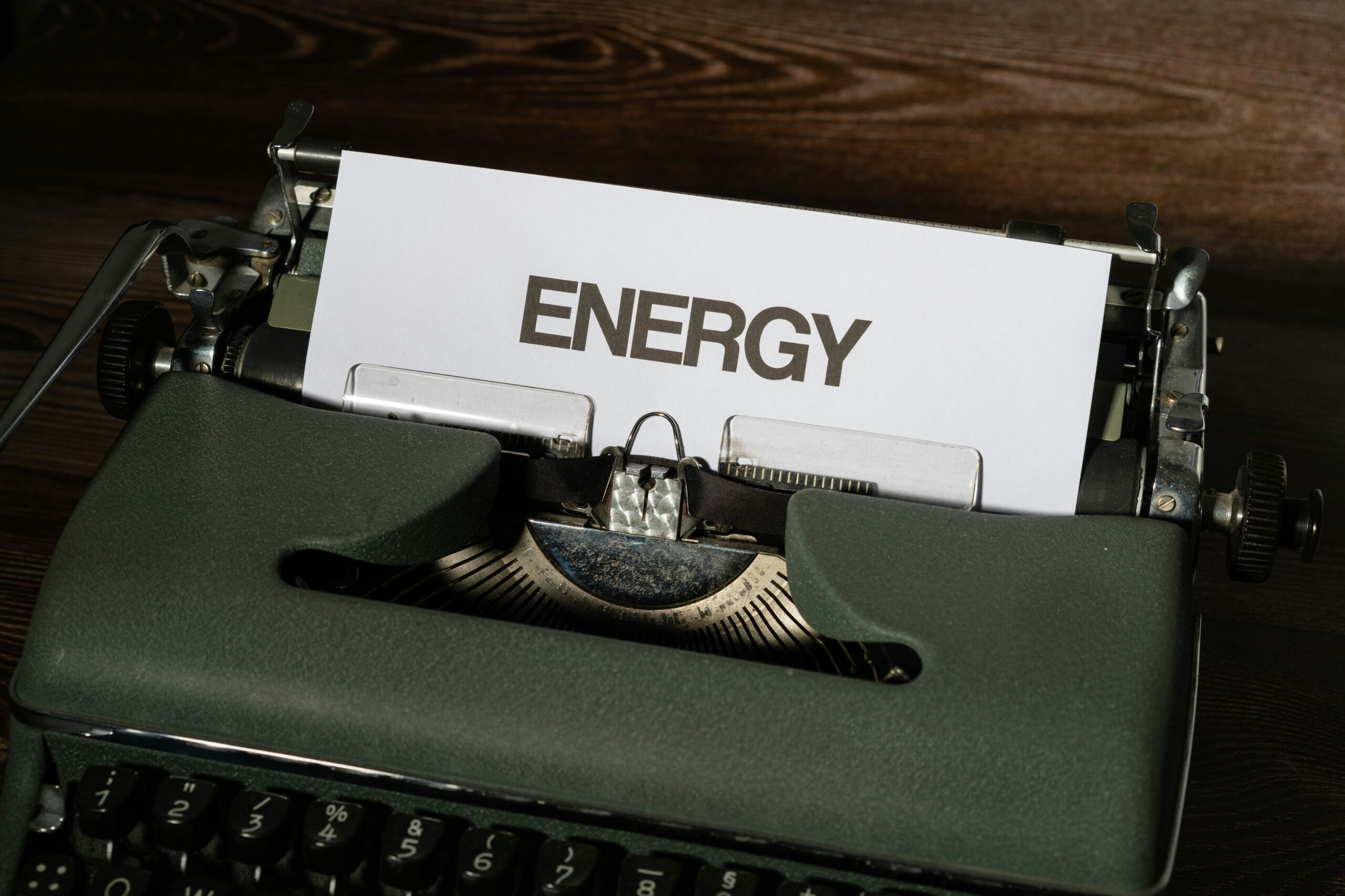A close-up of a vintage typewriter with a sheet of paper that reads “ENERGY” in bold letters, symbolising the importance of managing energy at work for sustainable productivity and wellbeing.